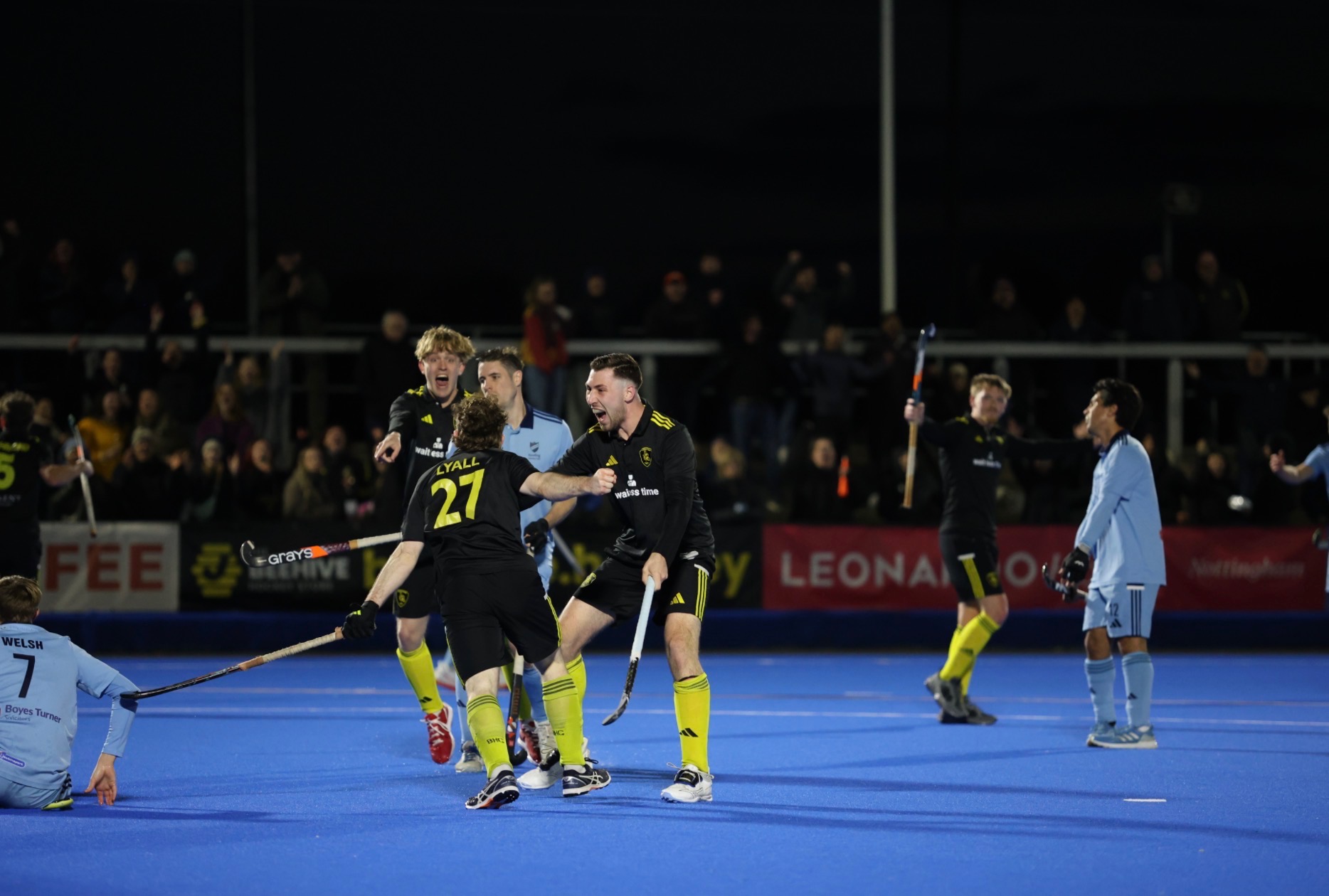 Beeston players celebrate a goal in front of a packed stand at Nottingham Hockey Centre